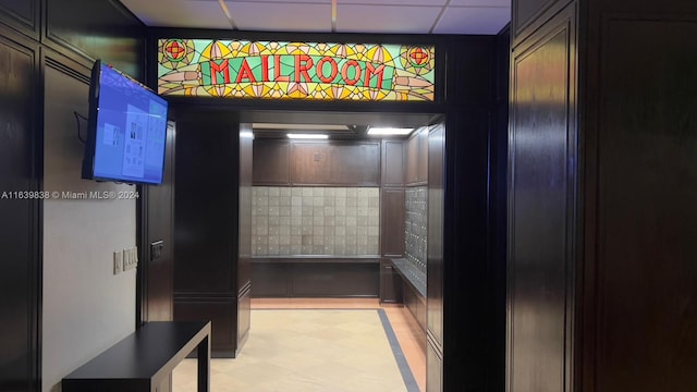 interior details with tile patterned floors and a paneled ceiling