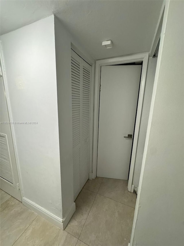 corridor featuring light tile patterned floors