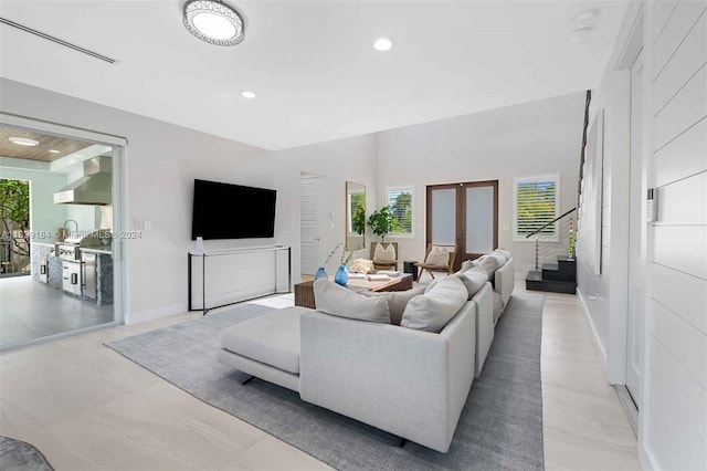 living room featuring light tile patterned floors, french doors, and plenty of natural light