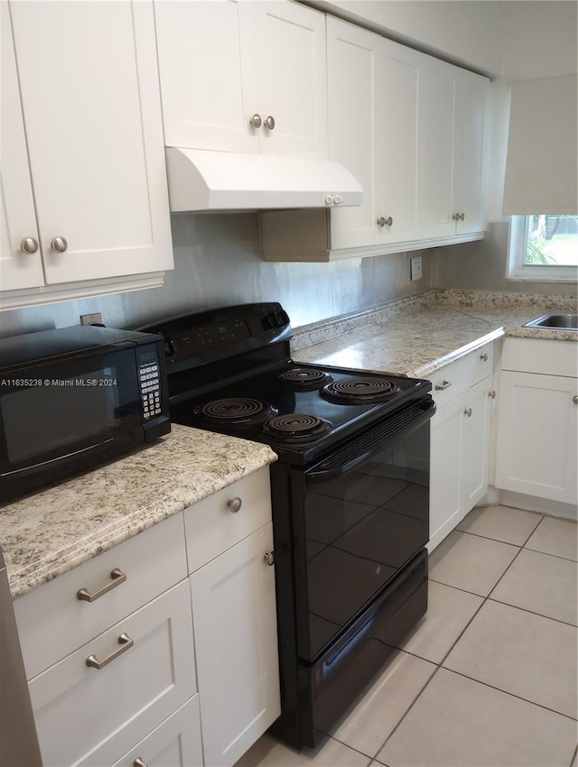 kitchen with light stone countertops, white cabinetry, light tile patterned floors, and black appliances