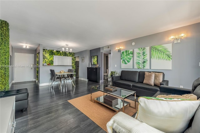 living room with dark wood-type flooring and an inviting chandelier