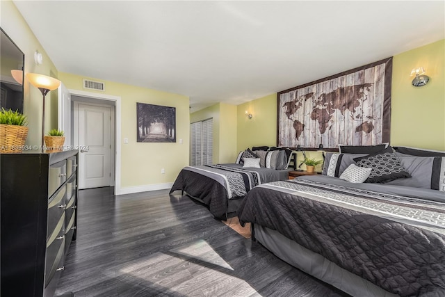 bedroom featuring dark wood finished floors, visible vents, a closet, and baseboards