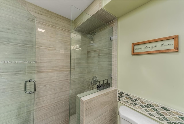 bathroom featuring a shower stall and toilet