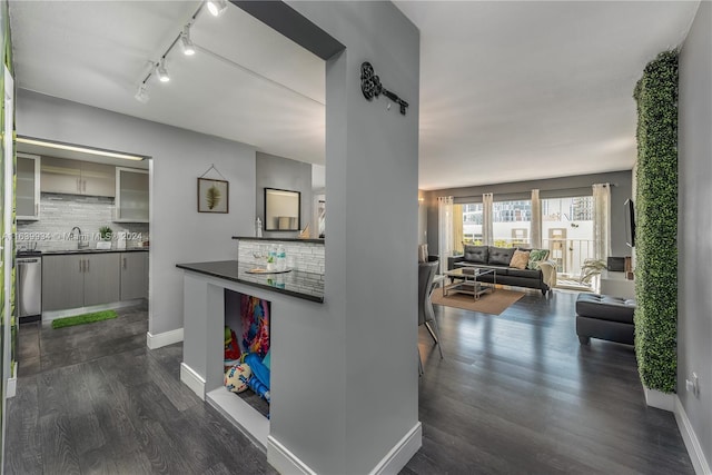 kitchen featuring decorative backsplash, open floor plan, glass insert cabinets, dark wood-style flooring, and dark countertops