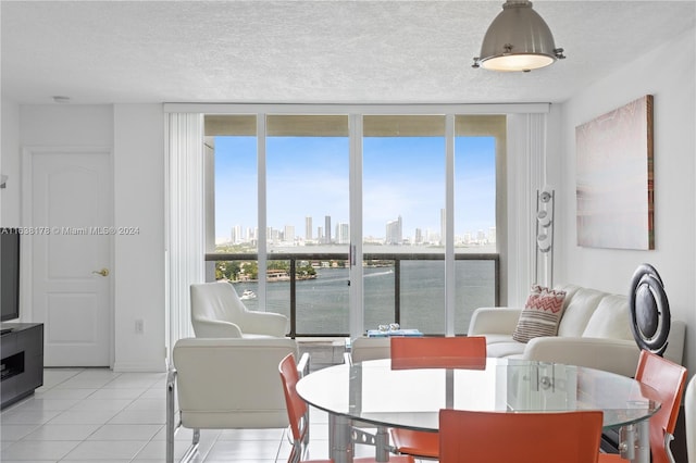 dining space with a wealth of natural light, light tile patterned flooring, and a textured ceiling