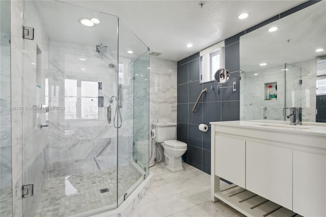 bathroom featuring walk in shower, vanity, tile walls, and toilet