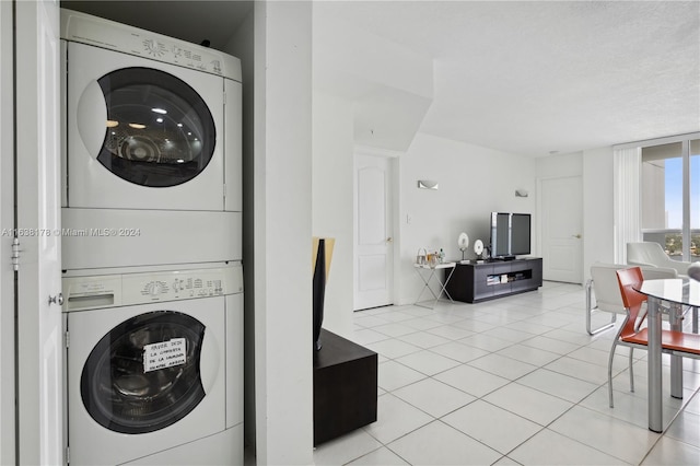 washroom with light tile patterned floors and stacked washer and dryer