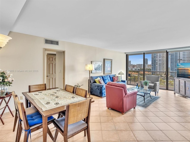 tiled dining space featuring a wall of windows