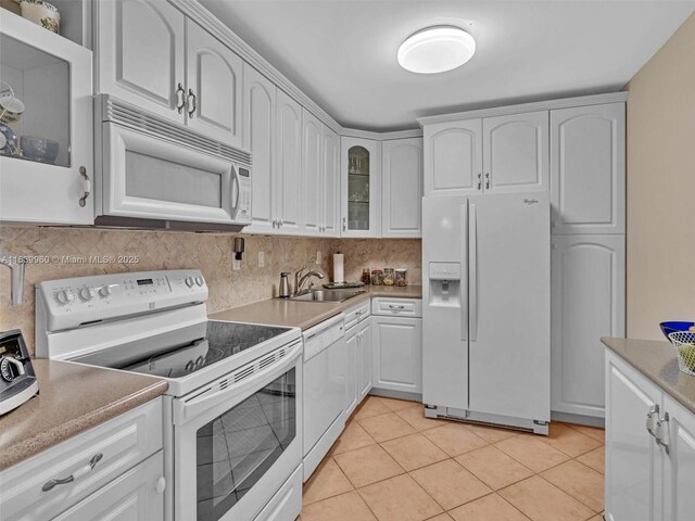 kitchen featuring tasteful backsplash, sink, white appliances, and white cabinets