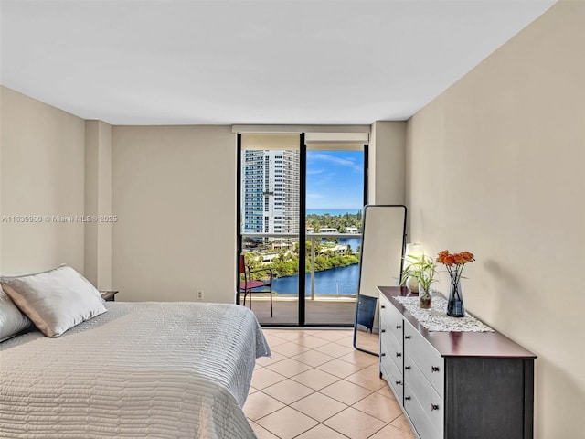 tiled bedroom with expansive windows and a water view