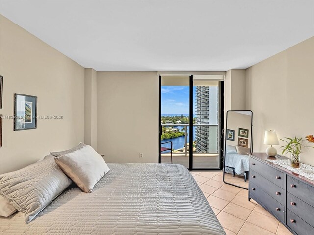 tiled bedroom with access to outside, floor to ceiling windows, and a water view