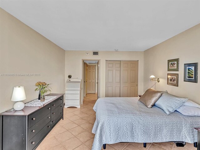 bedroom featuring light tile patterned floors and a closet