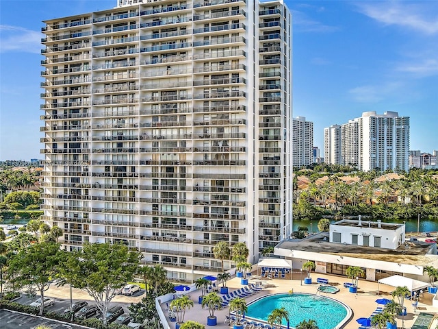 view of building exterior featuring a community pool and a water view