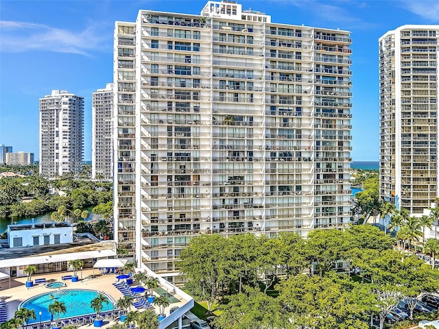 view of property with a view of city, a community pool, and a water view