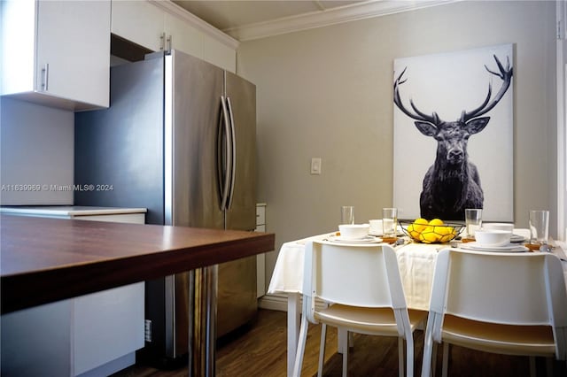 dining area with crown molding and dark wood-type flooring