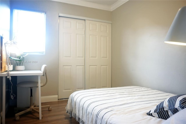 bedroom with crown molding, multiple windows, hardwood / wood-style flooring, and a closet