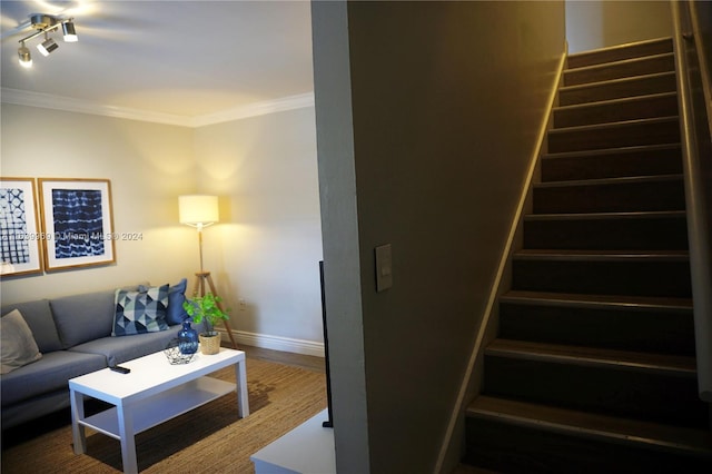 stairway with rail lighting, crown molding, and hardwood / wood-style flooring