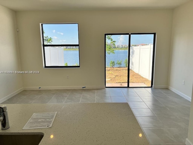 tiled spare room with a water view