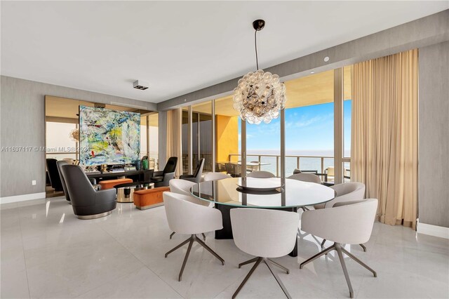 dining room with a notable chandelier, floor to ceiling windows, a water view, and tile patterned floors