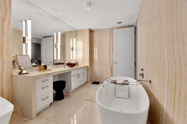 bathroom featuring concrete floors, toilet, wooden walls, vanity, and a tub