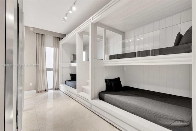 bedroom featuring light tile patterned flooring and rail lighting