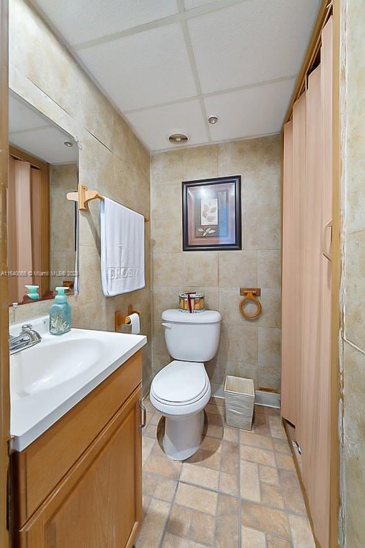 bathroom featuring tile walls, tile patterned floors, vanity, and toilet