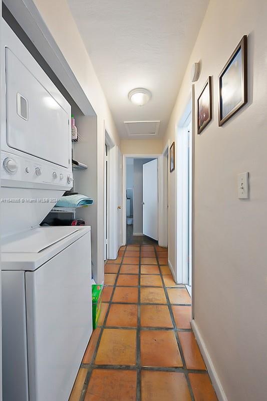 washroom with stacked washer / drying machine and tile patterned floors