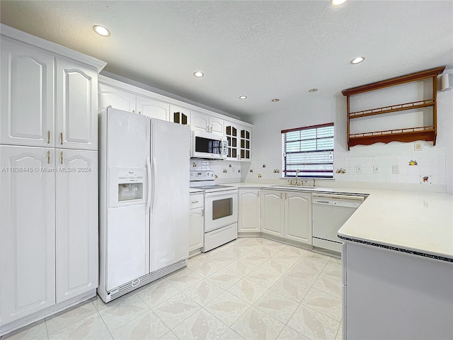 kitchen featuring sink, tasteful backsplash, white appliances, and light tile patterned floors