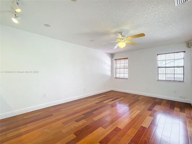 empty room featuring ceiling fan, a textured ceiling, and hardwood / wood-style floors