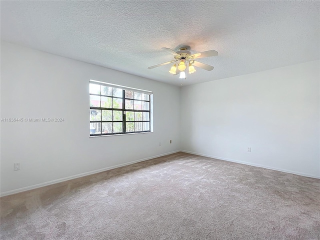 spare room with ceiling fan, a textured ceiling, and carpet