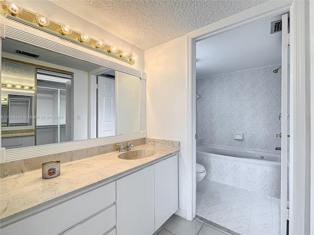 full bathroom with a textured ceiling, toilet, tile patterned floors, vanity, and bathing tub / shower combination