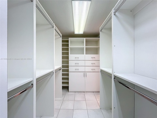 walk in closet with light tile patterned floors