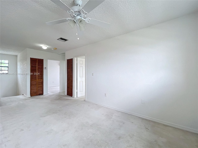 unfurnished bedroom with ceiling fan and a textured ceiling