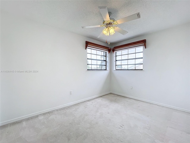 spare room featuring ceiling fan, a textured ceiling, and carpet