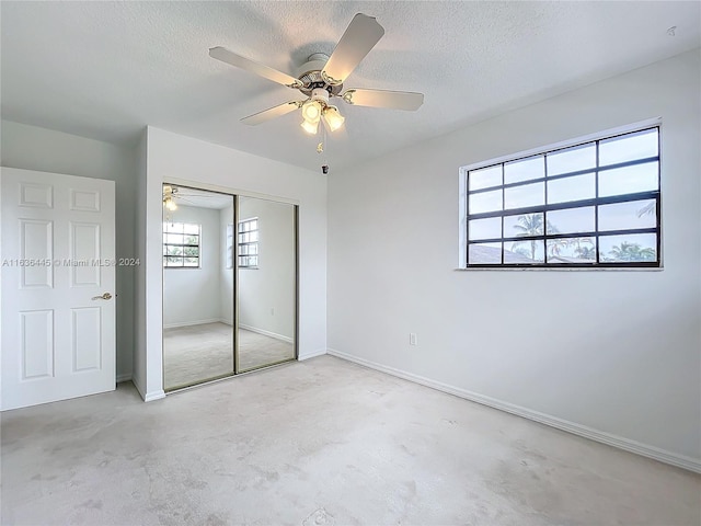 unfurnished bedroom featuring ceiling fan, a textured ceiling, and a closet