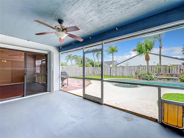 unfurnished sunroom with ceiling fan