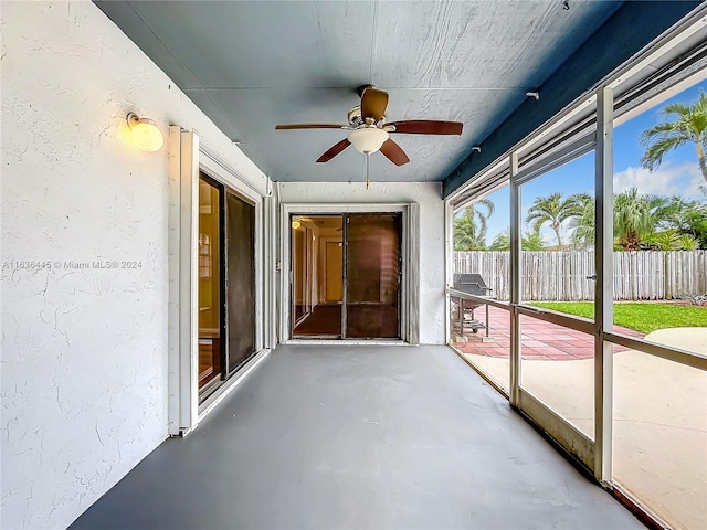 unfurnished sunroom featuring ceiling fan