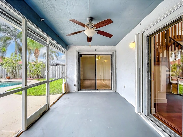 unfurnished sunroom with ceiling fan