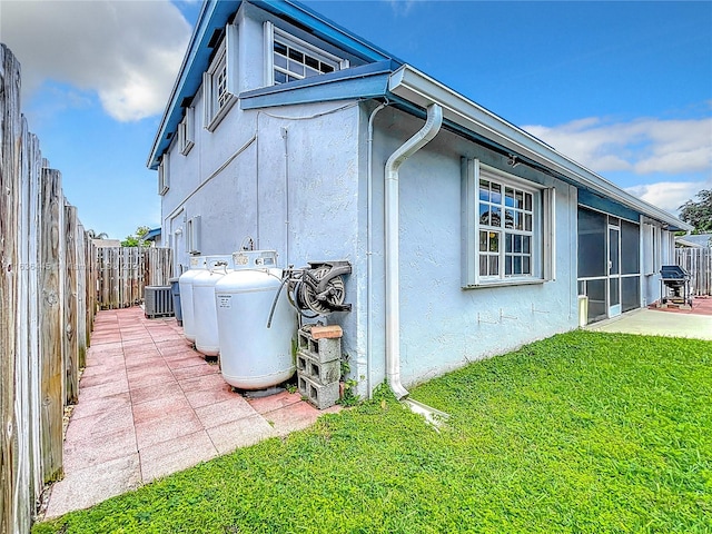 back of house with a patio area, central AC unit, and a yard