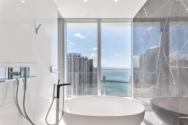 bathroom featuring a washtub and a water view