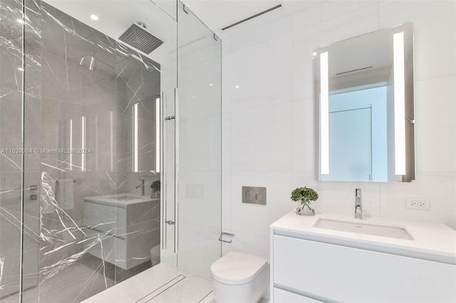 bathroom featuring a tile shower, vanity, and toilet