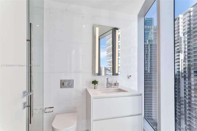 bathroom featuring vanity, toilet, and a shower with door