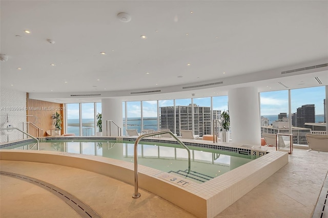 view of swimming pool with a jacuzzi and a water view