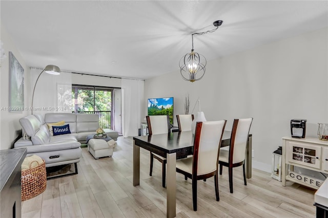 dining area featuring an inviting chandelier and light hardwood / wood-style floors