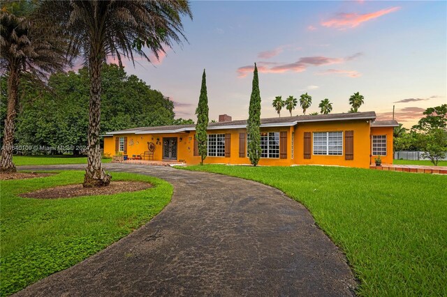 16255 SW 216th St, Miami, FL 33170 - ranch-style home featuring curved driveway, stucco siding, a front lawn, and a chimney