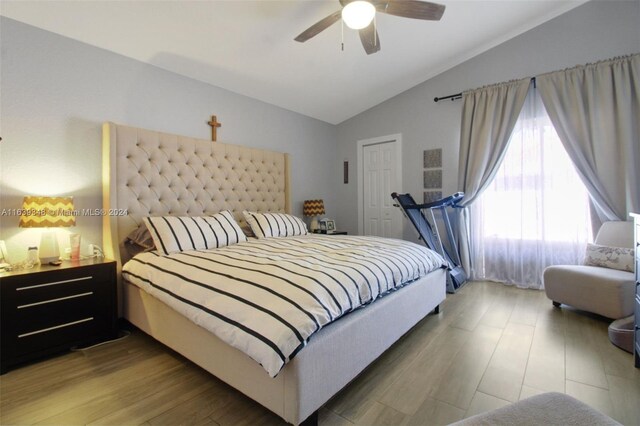 bedroom featuring ceiling fan, wood-type flooring, and vaulted ceiling