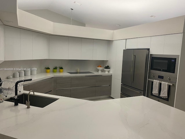 kitchen with light stone countertops, gray cabinetry, sink, black appliances, and decorative backsplash