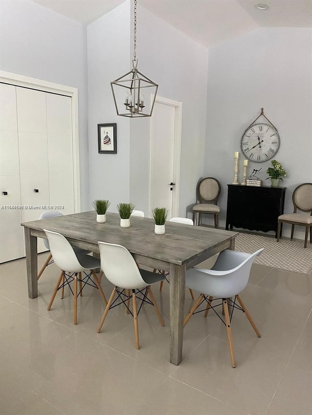 dining space with light tile patterned floors and an inviting chandelier