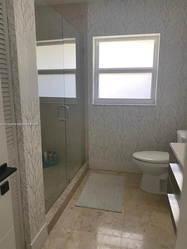 bathroom with a shower with door, toilet, and tile patterned floors