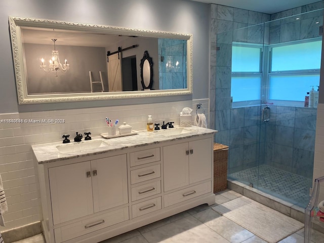 bathroom with dual bowl vanity, backsplash, tile patterned flooring, and an enclosed shower